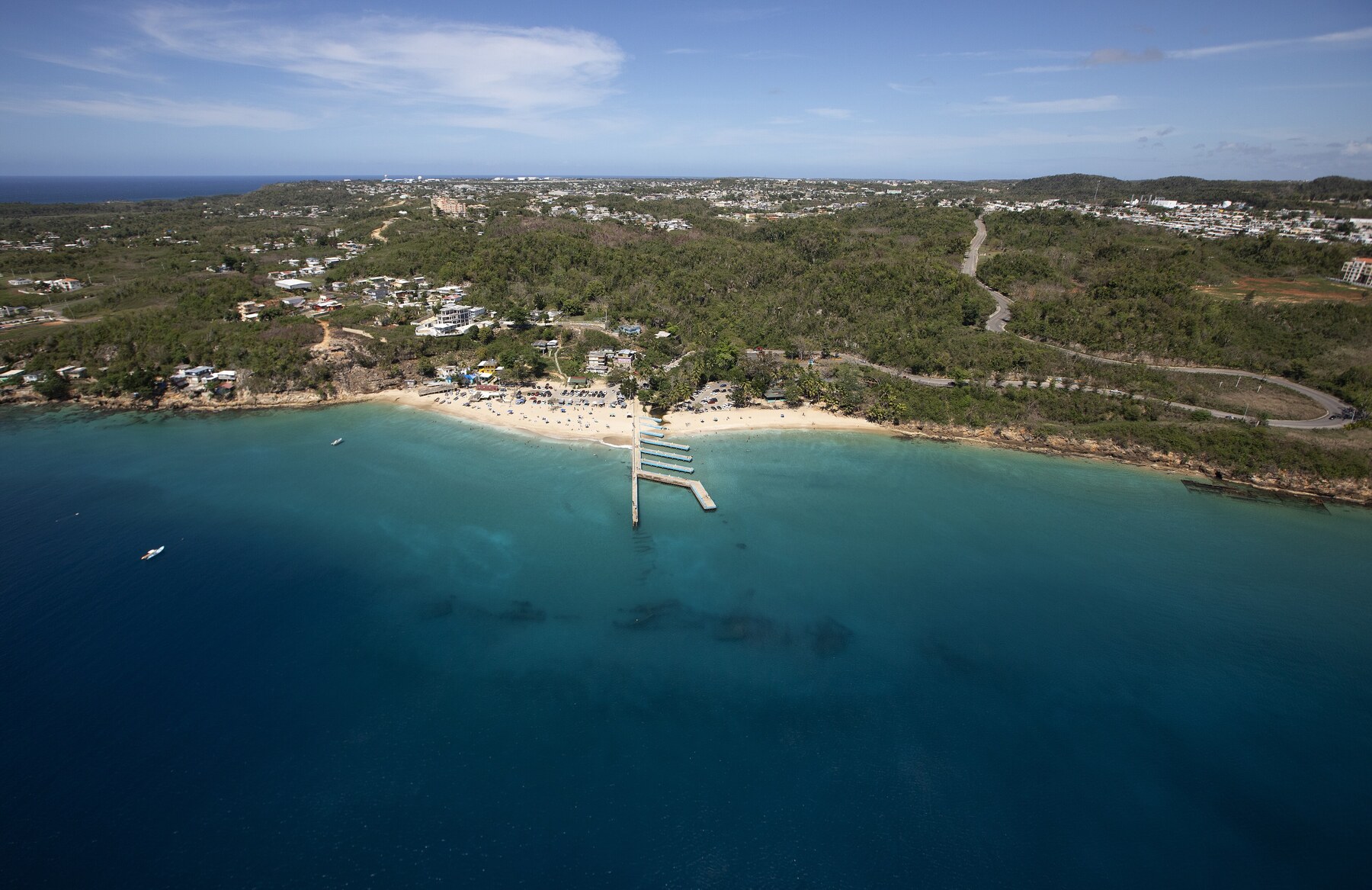 Aerial view of Crash Boat Beach and its pier extending into turquoise water in Aguadilla.