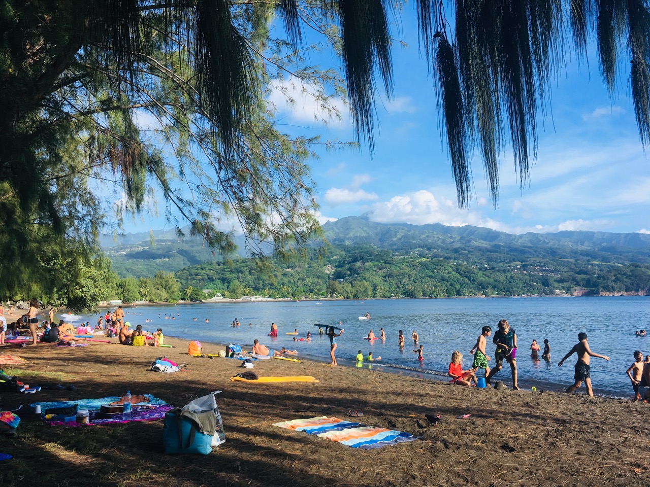 Black sand and swimmers at Pointe Vénus on Tahiti
